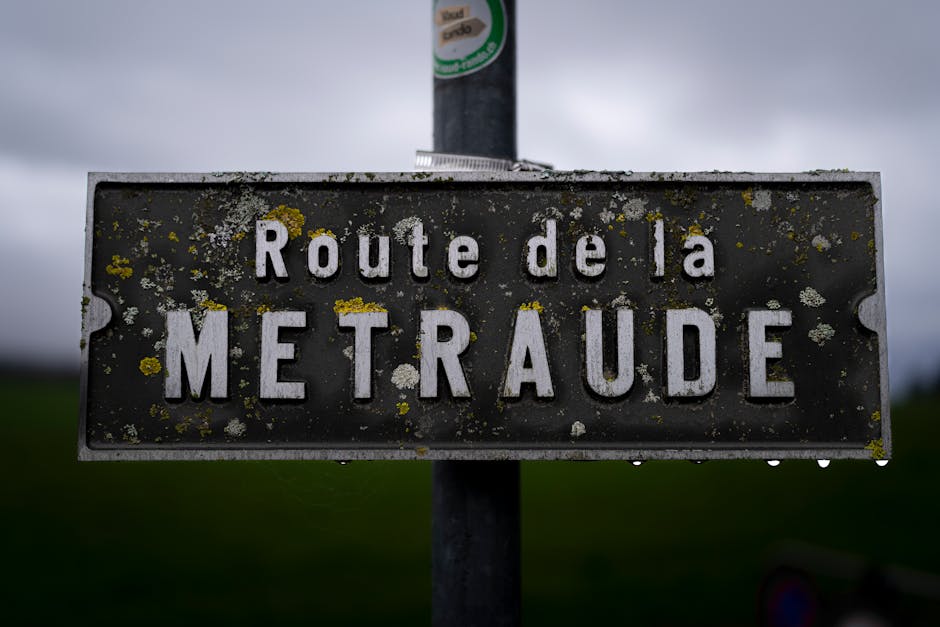 Close-up of a rustic road sign 'Route de la METRAUDE' in Lausanne, Switzerland.